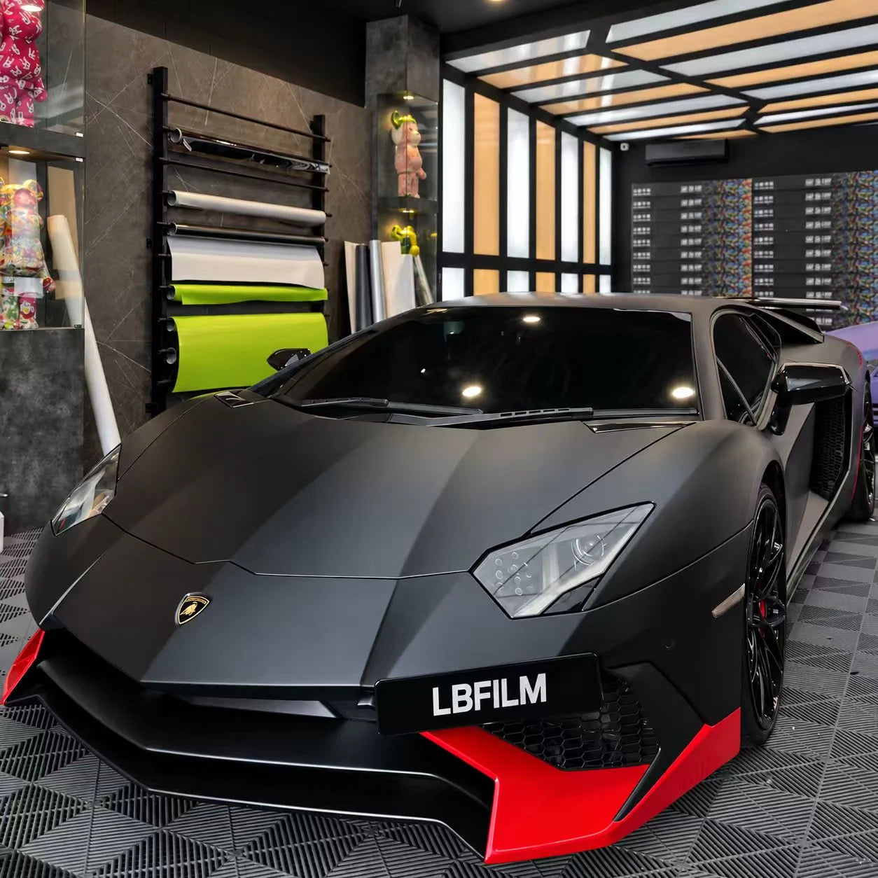Matte black Lamborghini Aventador with red accents in the LBFILM workshop